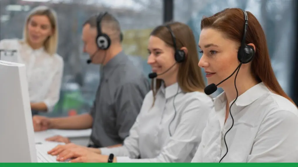 Inbound call center agents wearing headsets working at computers