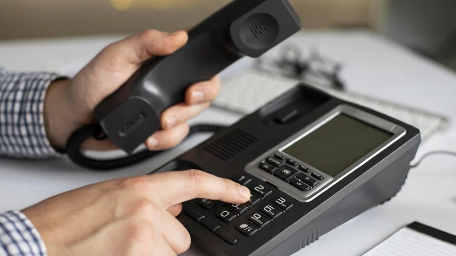 A picture of man dialing a call from a phone.