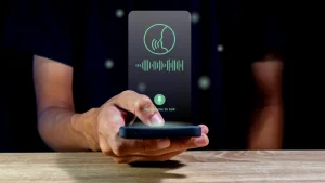 A man playing visual voicemail in his mobile phone.