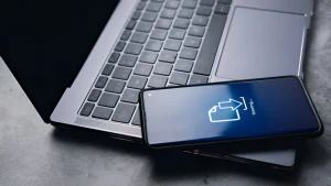 A cellphone resting on top of a laptop keyboard.