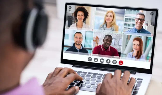 Person Using A Laptop For A Video Conference Call With Six Colleagues, Showcasing Remote Communication Through An Online Meeting Platform.