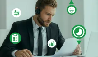 Business professional wearing a headset, reviewing documents at a desk with laptop.