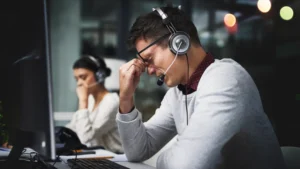 A guy Experiencing call center burnout in his workplace.